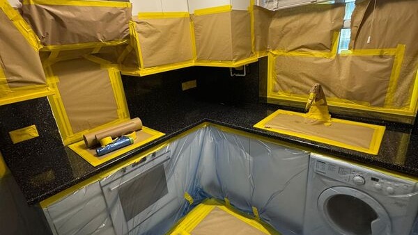 kitchen-cabinets-masked-in-brown-paper-and-tape-16x9-1 How a Kitchen Respray Job Runs From Booking to Handover